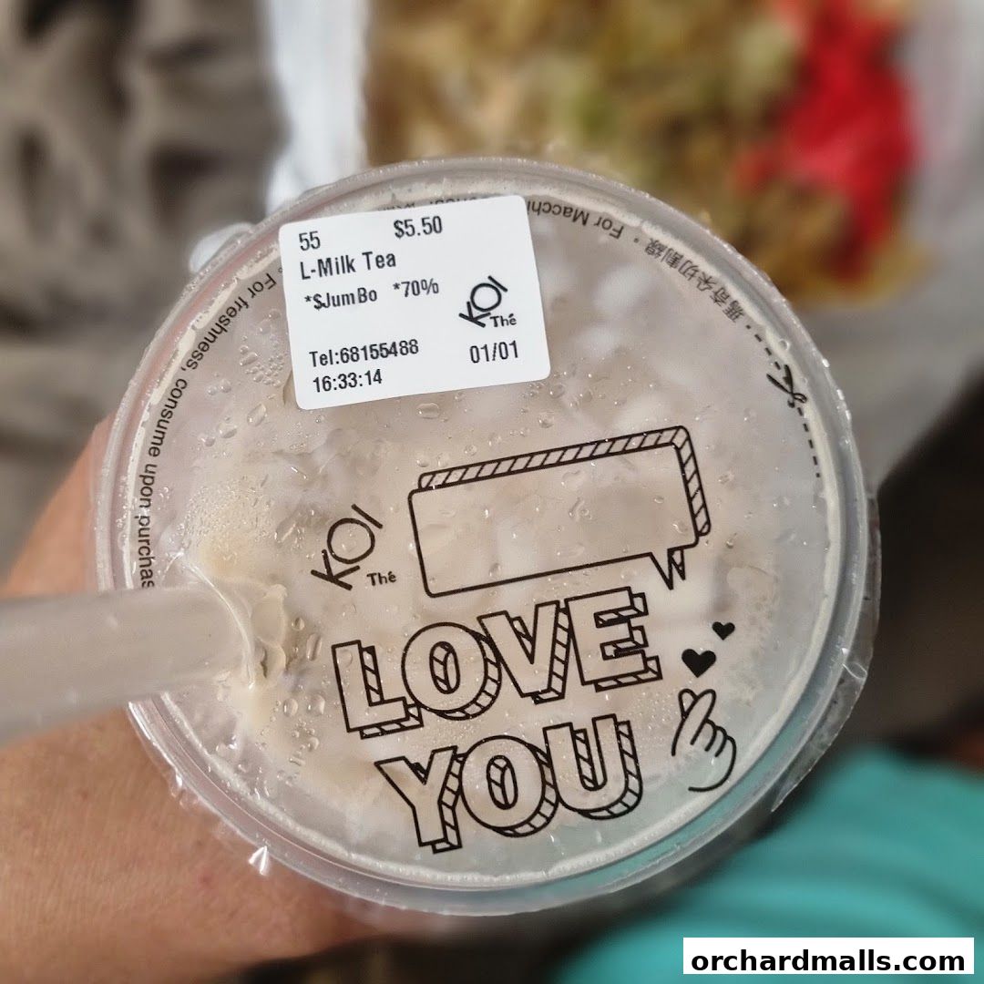 A close-up of a KOI Thé L-Milk Tea cup with a 'Love You' message.