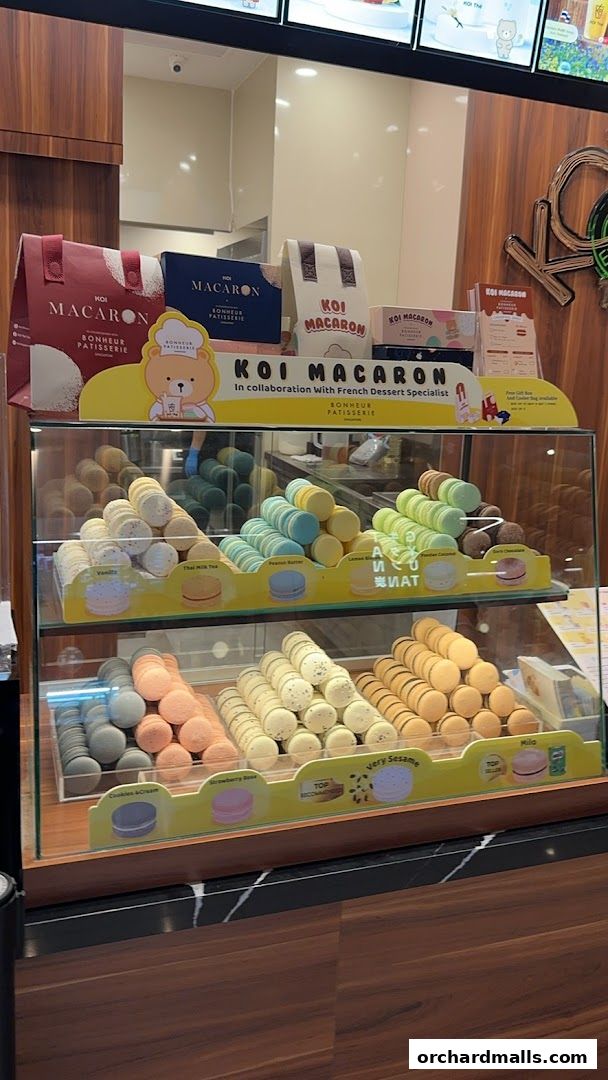 A display case filled with colorful macarons from KOI Macaron.