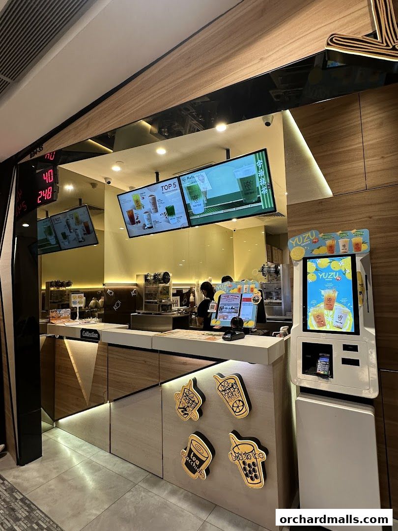 A modern bubble tea shop counter with digital menus and a self-order kiosk.