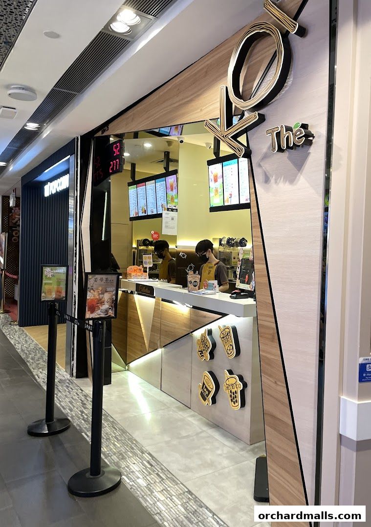 The entrance of KOI Thé, a bubble tea shop, with staff serving customers behind the counter.