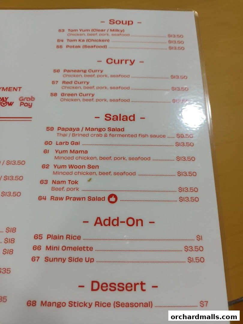A close-up of a Thai restaurant menu featuring soups, curries, salads, add-ons, and desserts.