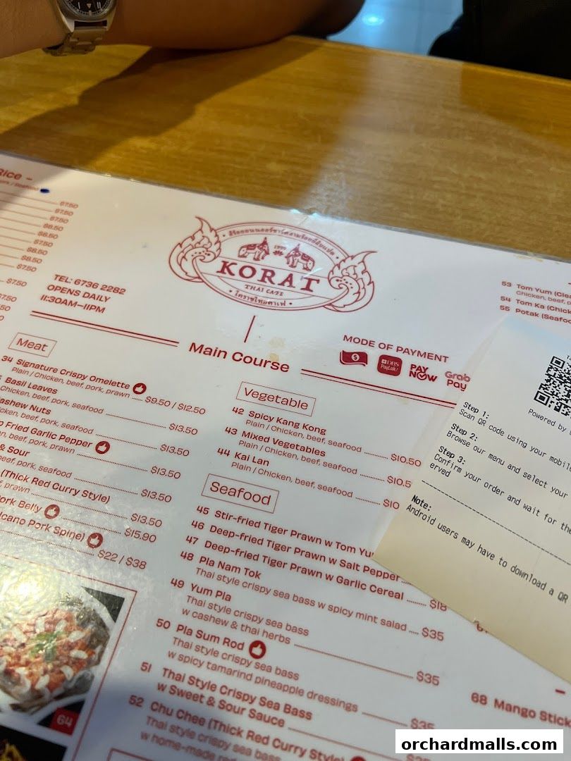 A menu from Korat Thai Cafe showing main courses, vegetables, and seafood options.