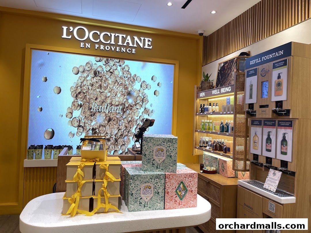 Interior view of L'Occitane shop showcasing gift sets, skincare products, and a refill station.