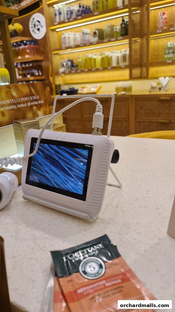 A close-up of a skin analysis device displaying magnified hair strands at L'Occitane.
