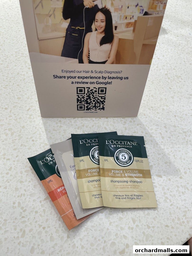 L'Occitane hair care samples and a sign encouraging Google reviews.