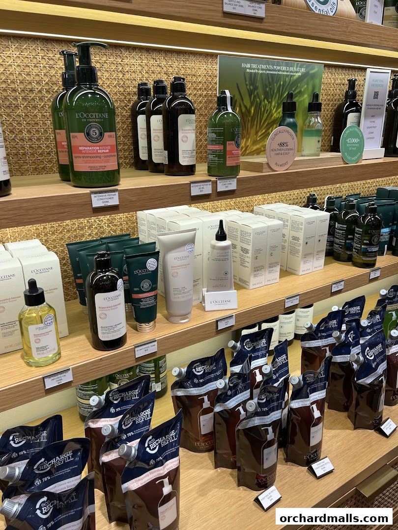 Shelves stocked with L'Occitane hair care products, including shampoos, conditioners, and refill pouches.