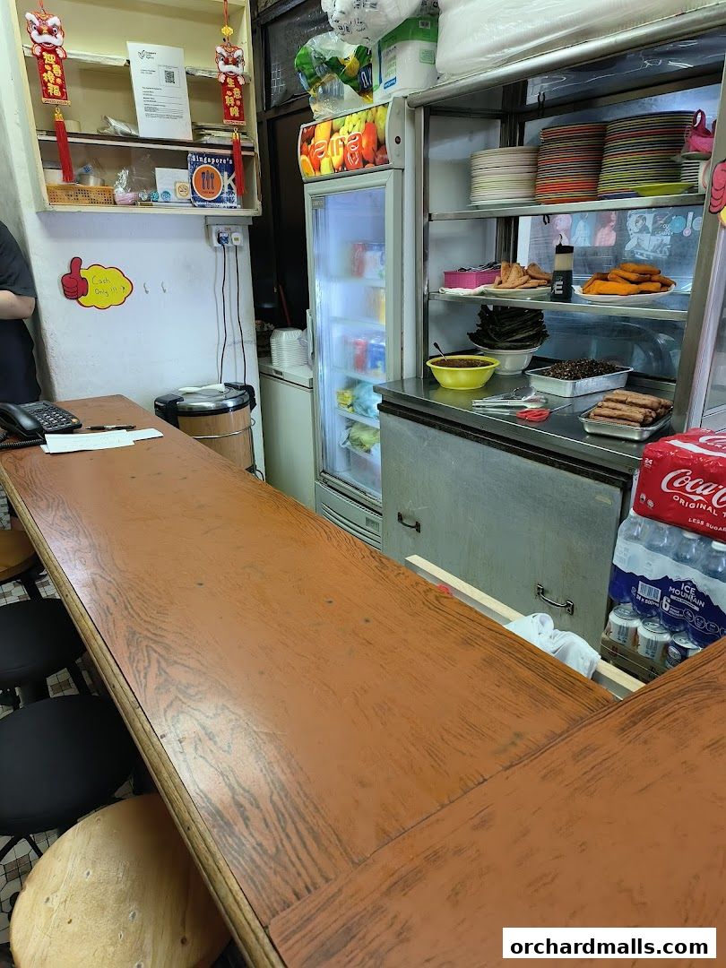 Interior view of a snack bar counter with a refrigerator and food display.