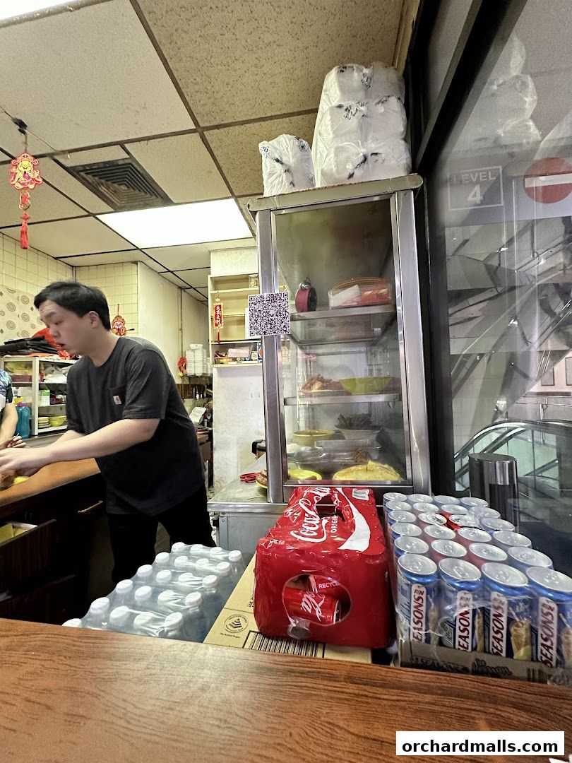A man works behind the counter at La Pona Snack Bar Nasi Lemak.