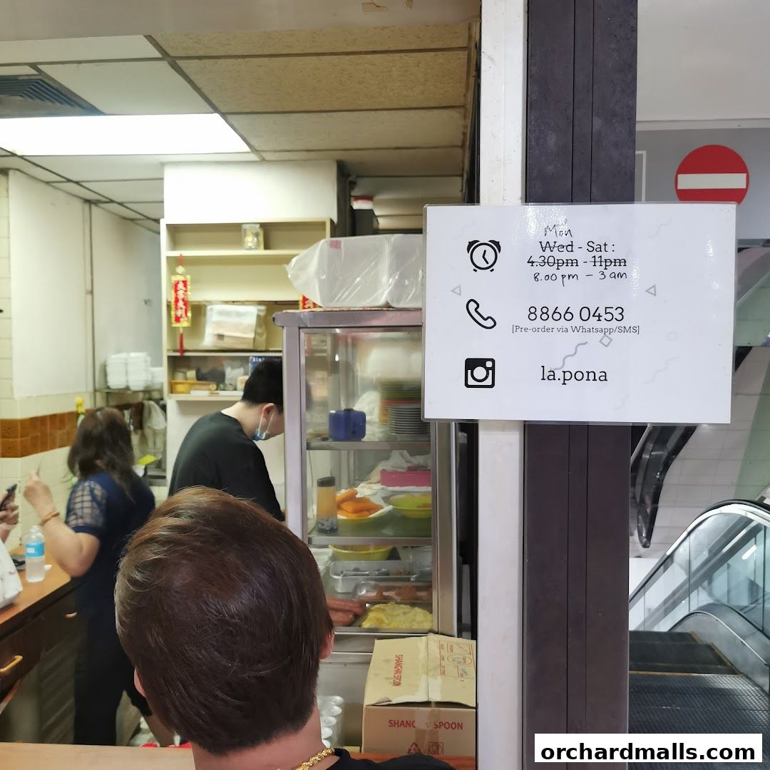A sign with operating hours and contact details for La Pona Snack Bar.