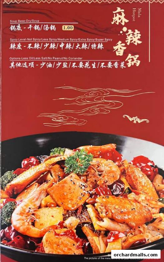 A close-up of a spicy mala hotpot dish with shrimp, tofu, and chicken wings.