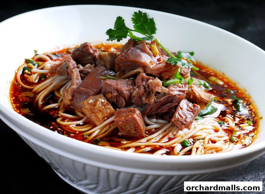 A close-up shot of a steaming bowl of beef noodle soup with fresh herbs.