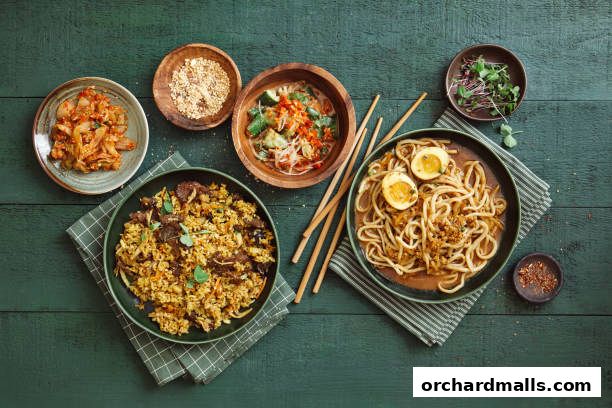 A top-down view of delicious Asian dishes including fried rice, noodles, and kimchi.