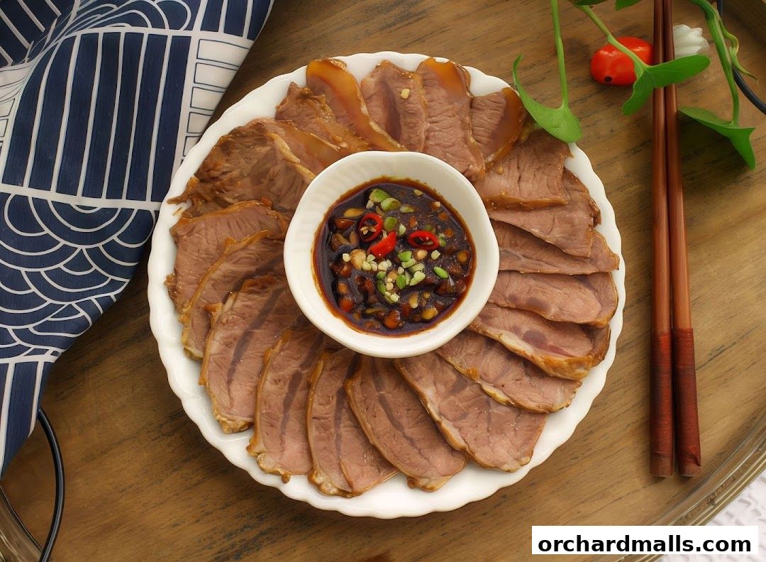 A plate of thinly sliced beef with a dipping sauce and chopsticks.