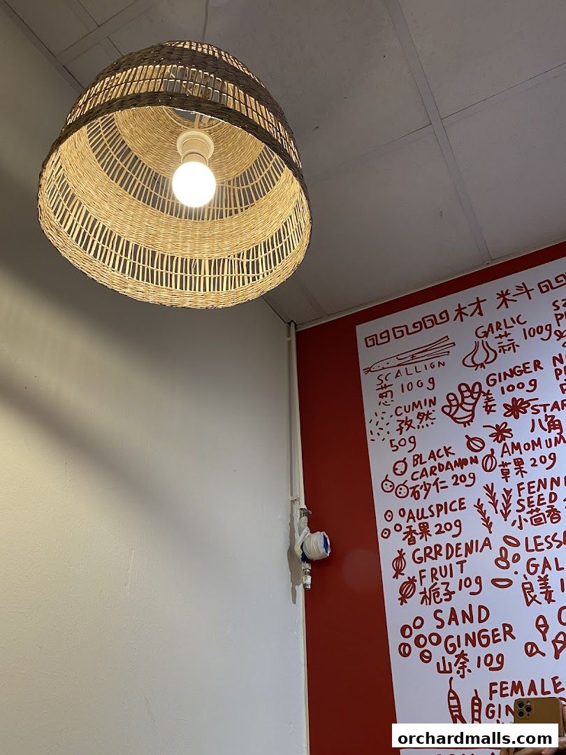 A handwritten menu with various ingredients and their prices is displayed on a red wall.