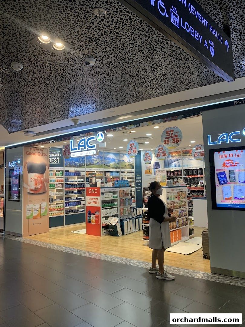 A LAC Nutrition store with a wide selection of health supplements and a staff member standing at the entrance.