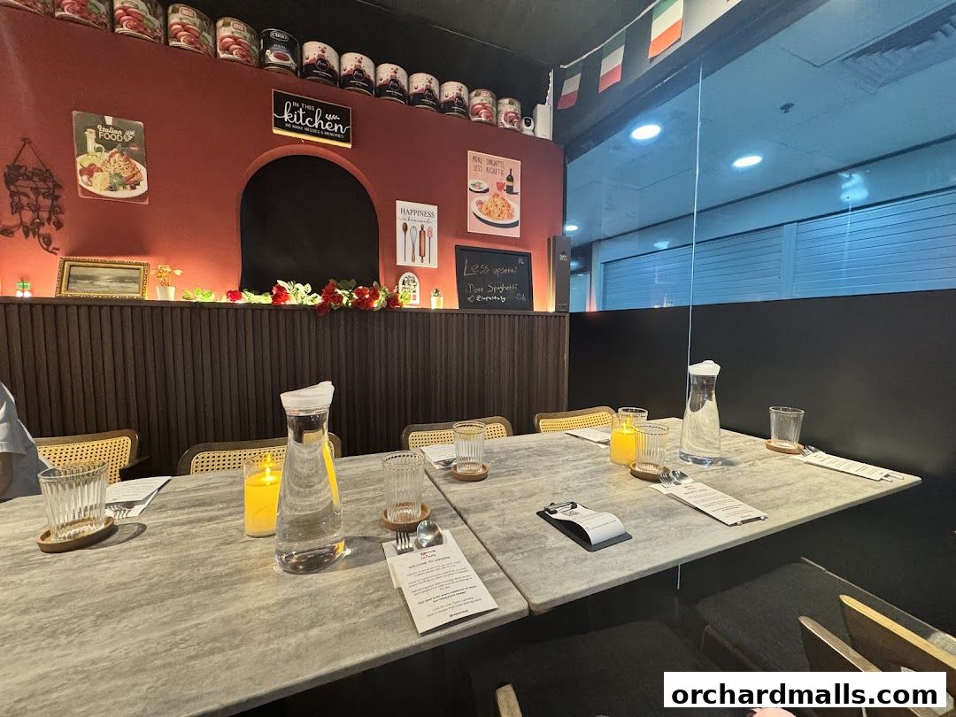 A table setting at LaPasta restaurant with water pitchers, glasses, and menus.