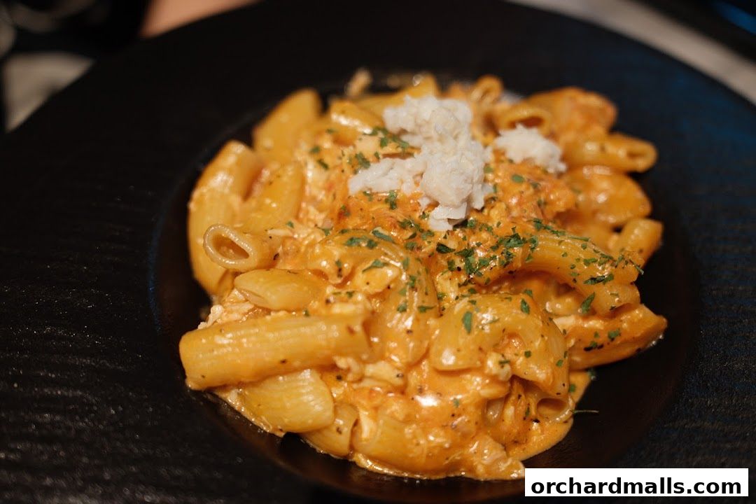 A close-up shot of a creamy pasta dish topped with crab meat and parsley.