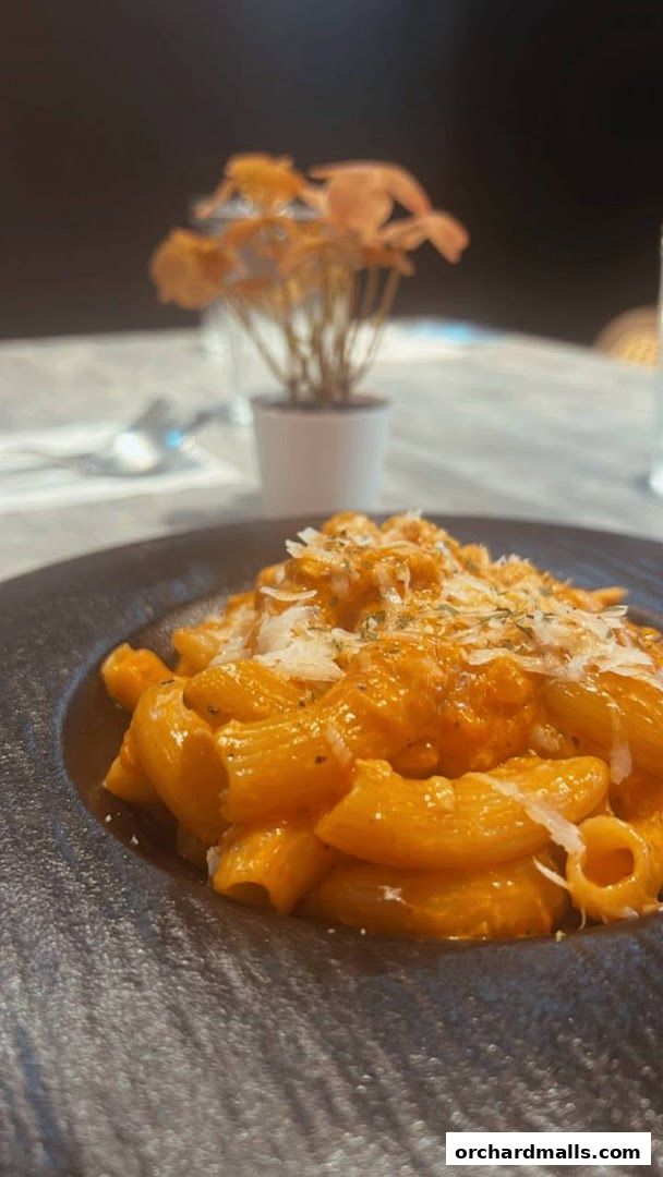 A close-up shot of a delicious pasta dish served in a dark bowl with grated cheese.