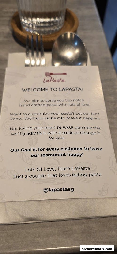 A welcome card from LaPasta restaurant with cutlery and a glass of water.