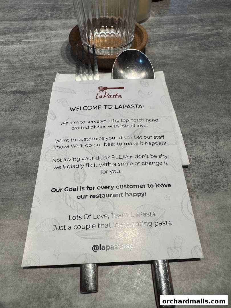 A welcome card from LaPasta restaurant with cutlery and a glass on a table.