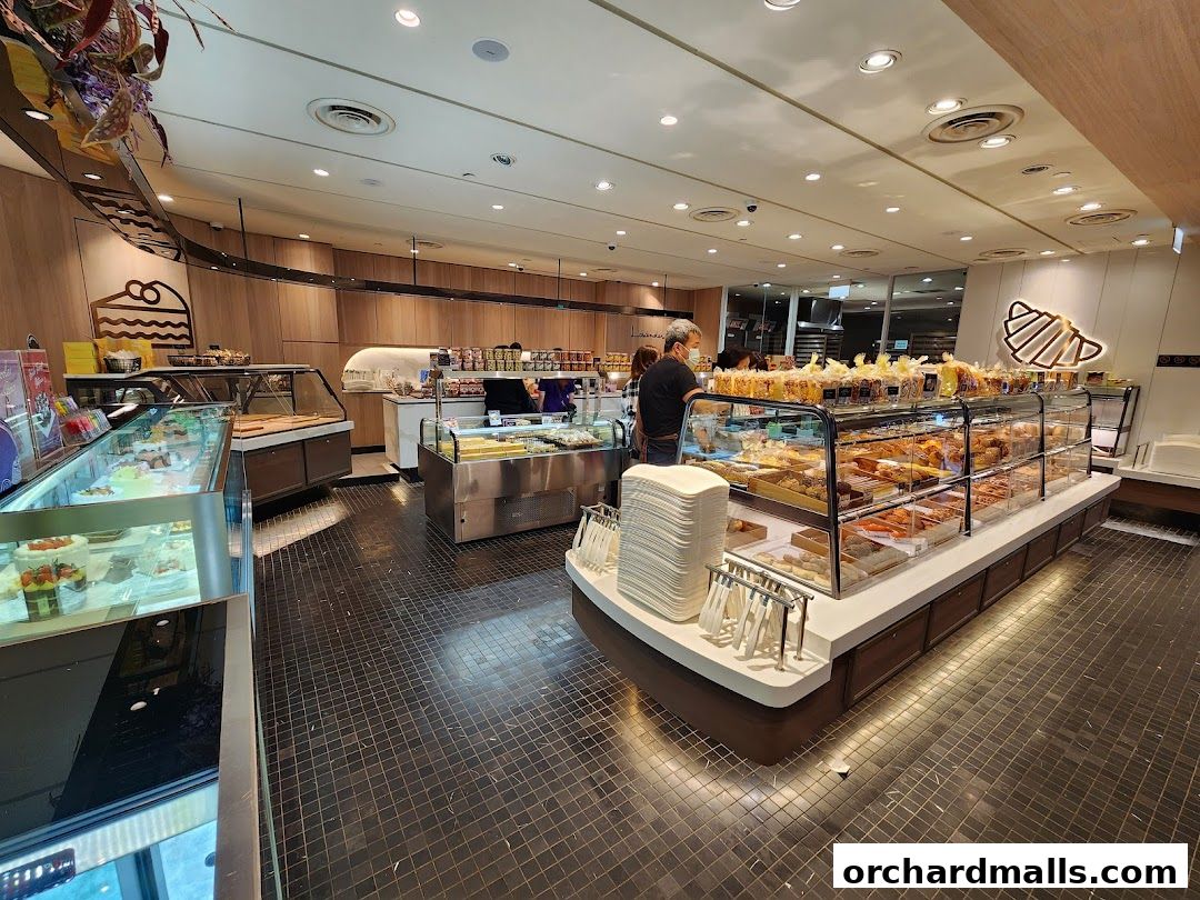Interior view of a bakery with display cases filled with pastries and cakes.