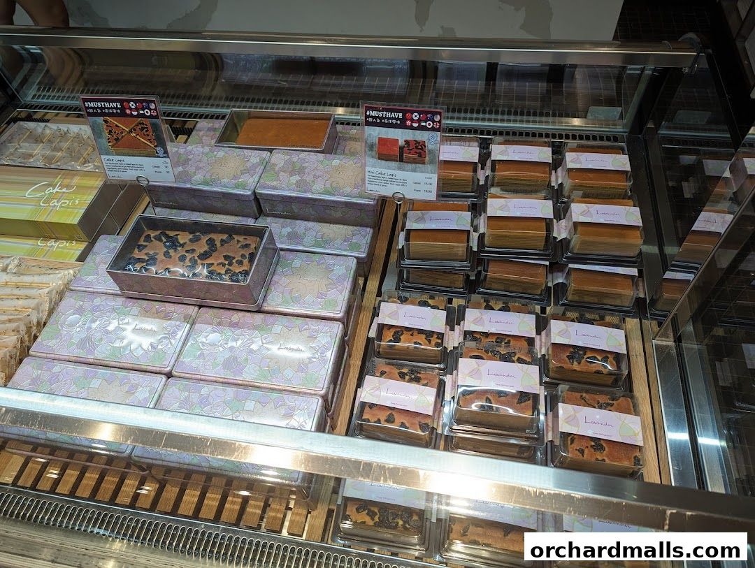 A display case filled with various layered cakes and baked goods from Lavender Bakery.