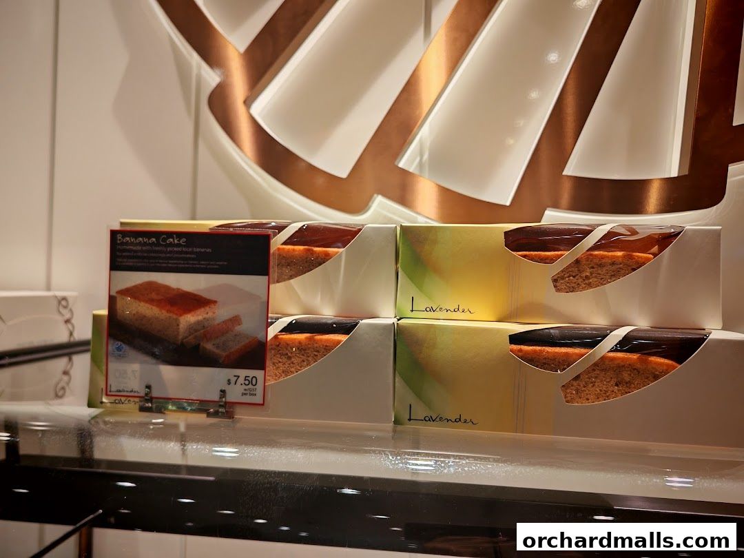 A display of individually packaged cakes with a sign for Banana Cake.