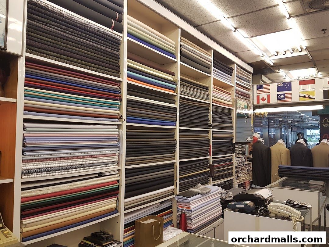 Interior of a tailor shop showcasing a vast selection of fabric rolls neatly stacked on shelves.