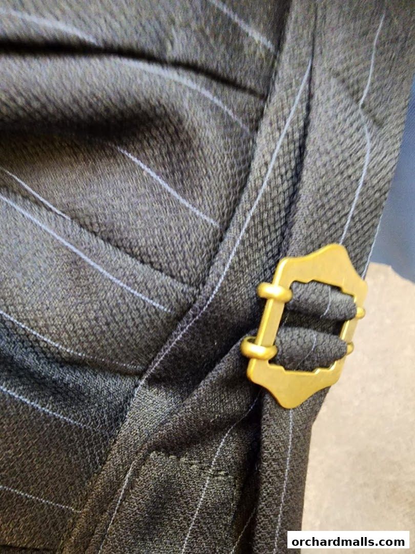 Close-up of a pinstripe fabric with a decorative gold buckle detail.