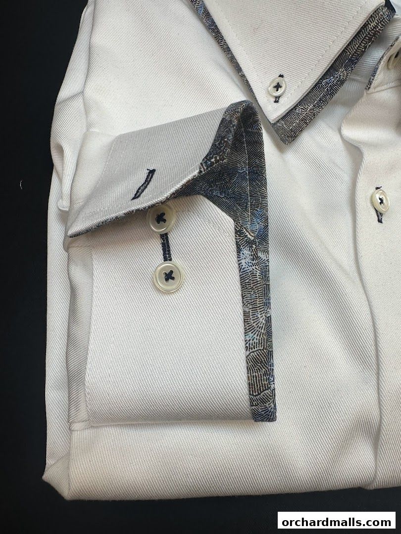 Close-up of a white dress shirt with patterned cuffs and collar details.