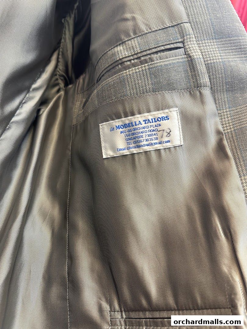 Interior view of a tailored suit jacket with a label from Le Modella Tailors.
