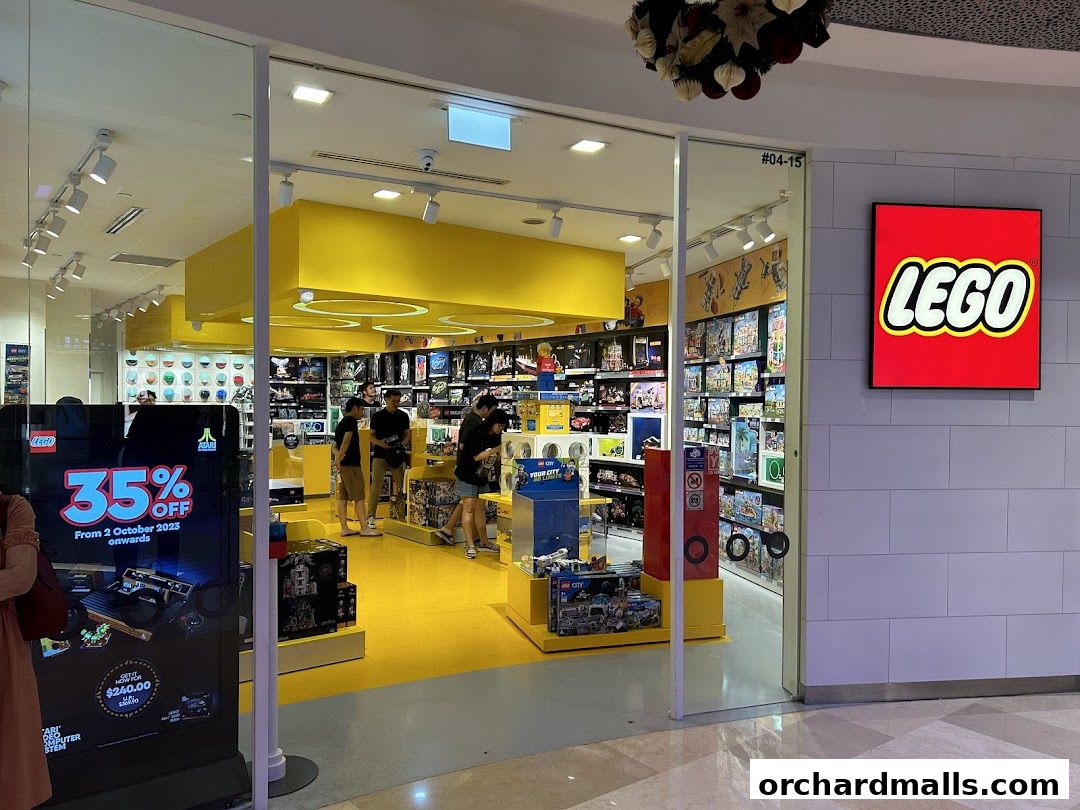 Interior view of a brightly lit LEGO Certified Store with various LEGO sets on display and customers browsing.