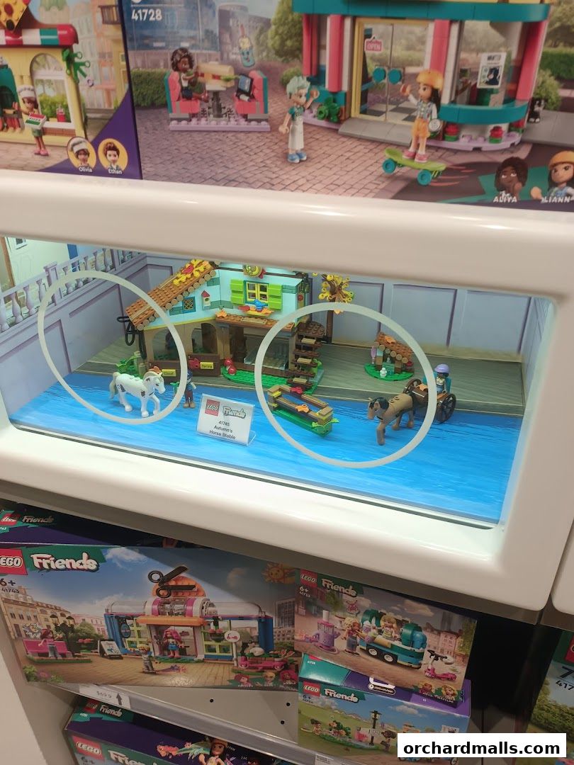 Display window showcasing LEGO Friends sets, including a horse stable and a cafe.