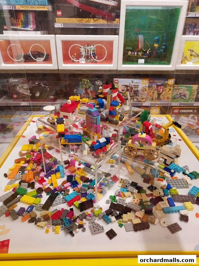 A display of colorful LEGO creations and loose bricks on a white surface.