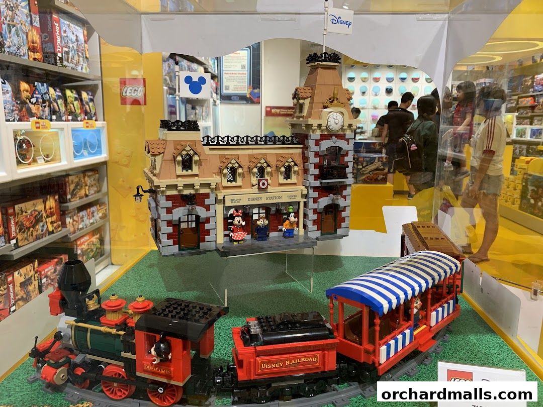LEGO Disney train station and train display with shoppers in the background.