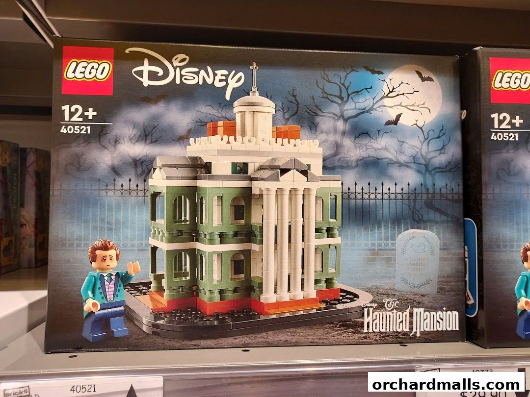 A LEGO Disney Haunted Mansion set is displayed on a shelf, featuring a minifigure and the iconic mansion.