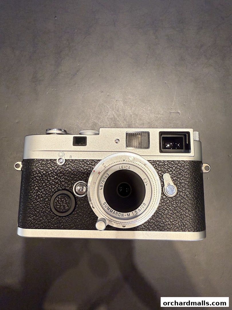 A close-up shot of a silver and black Leica Summicron-M 1:2/28 camera.