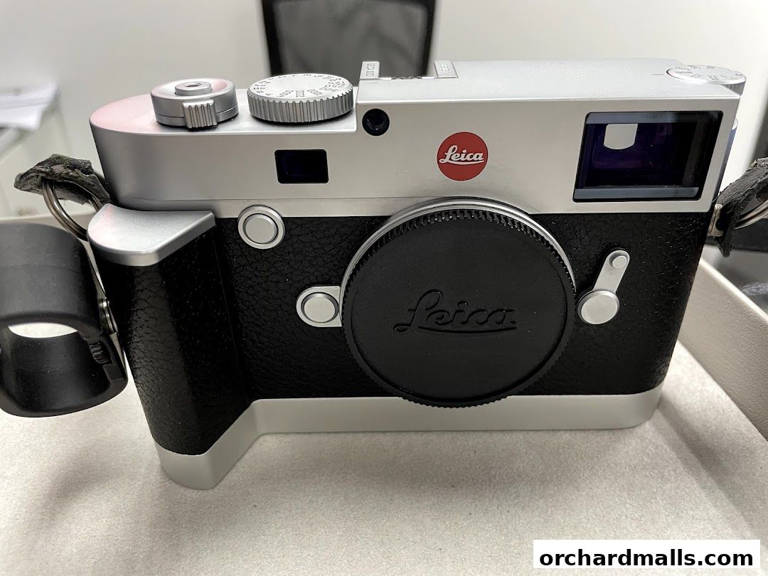 A close-up view of a silver and black Leica camera with its lens cap on.