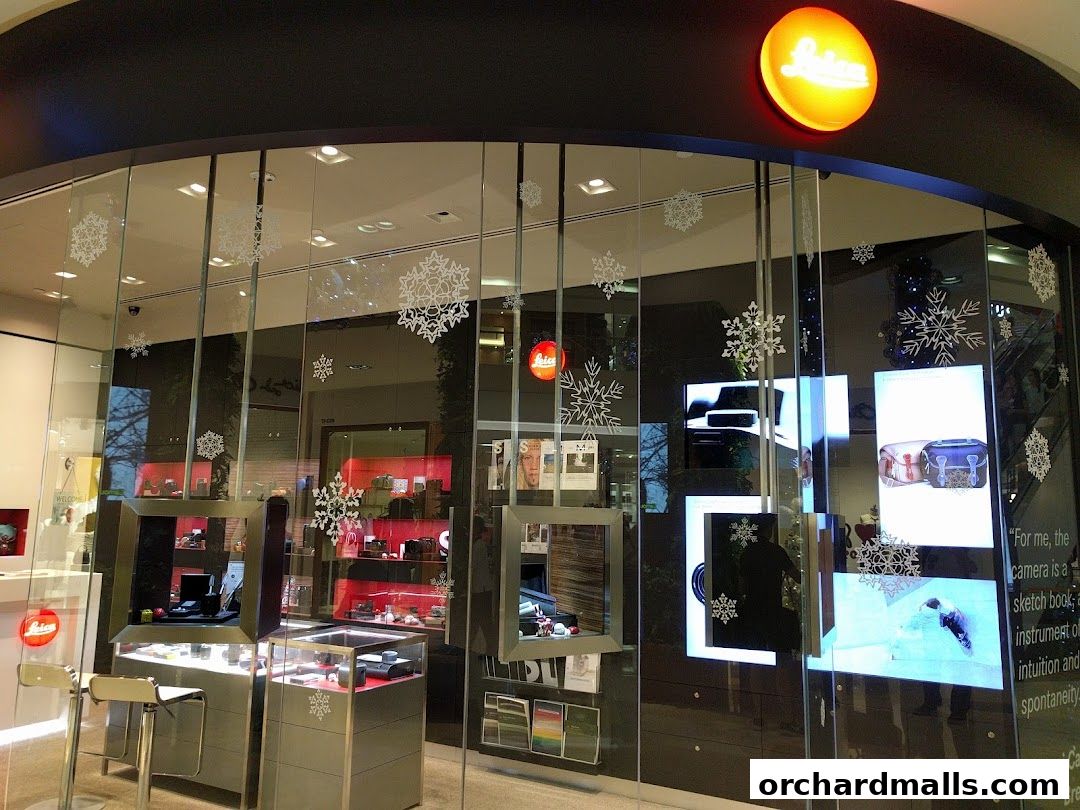 The Leica Store ION Orchard features a modern glass facade with illuminated displays showcasing products.
