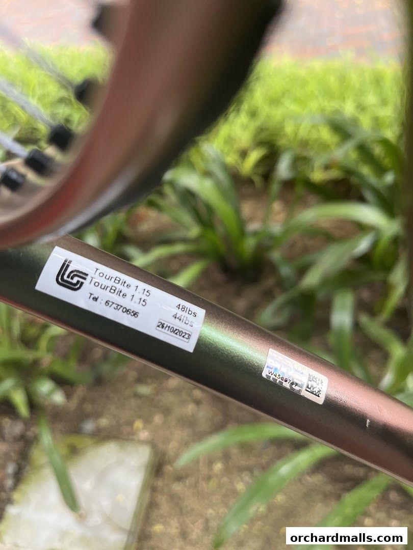 Close-up of a tennis racket with product details and a sticker.