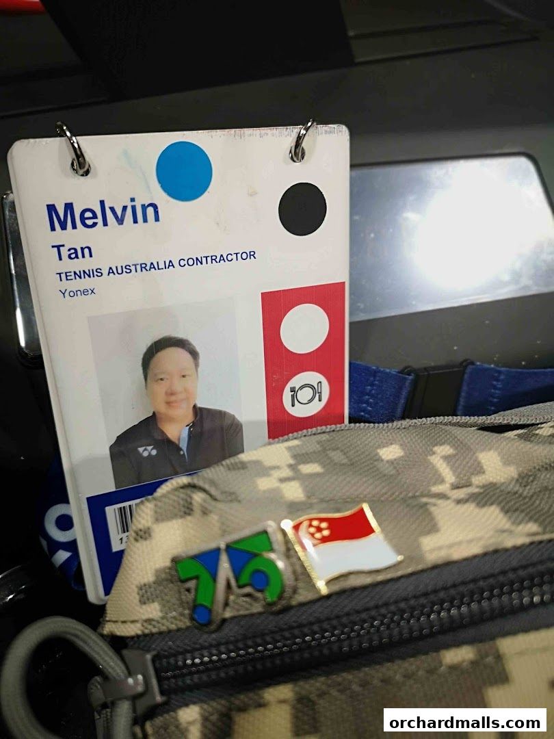 A close-up of a contractor's ID badge for Tennis Australia, with pins on a bag.