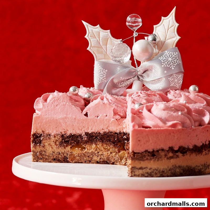 A festive pink cake with intricate frosting and holiday decorations on a pink cake stand.