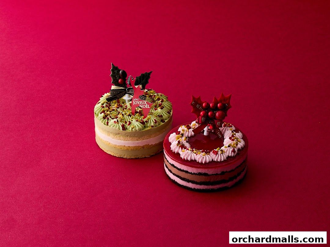 Two festive Christmas cakes, one green and one red, displayed on a vibrant red background.