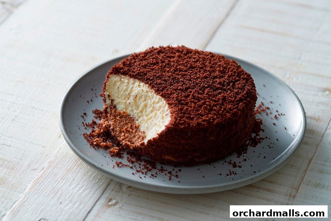 A slice of rich chocolate cake with creamy filling on a grey plate.
