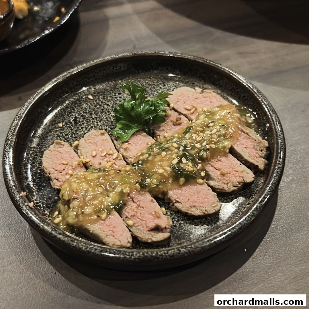 Thinly sliced beef with a savory sauce and sesame seeds, garnished with parsley.