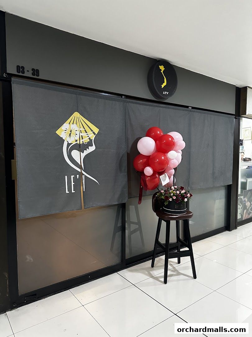 The entrance of a shop named LEV, decorated with balloons and a flower arrangement.