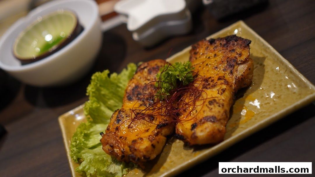 A close-up of grilled chicken with lettuce and garnish on a square plate.