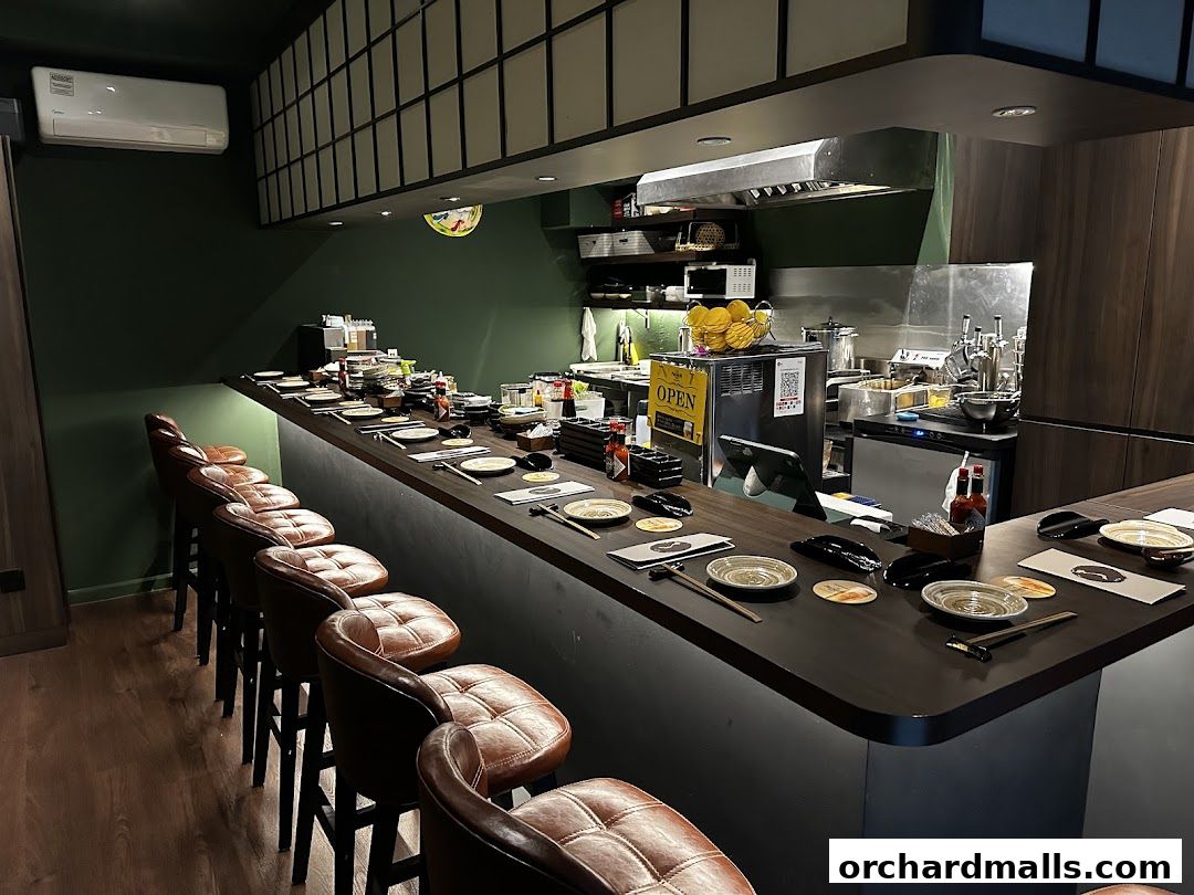 A modern restaurant counter with leather stools and place settings, ready for diners.