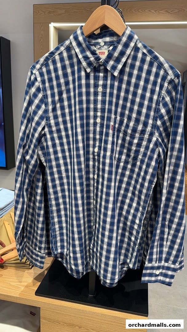 A blue and white checkered Levi's shirt is displayed on a hanger in a store.
