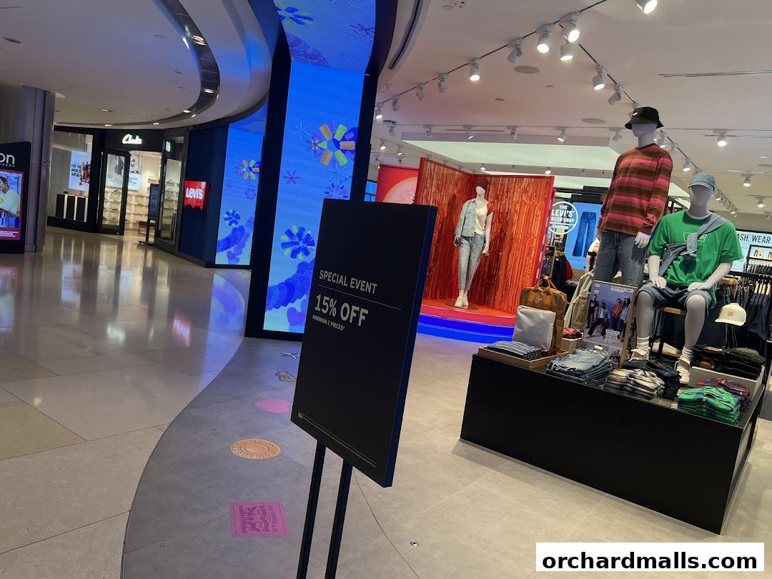 Mannequins display Levi's clothing inside a brightly lit store with digital displays.